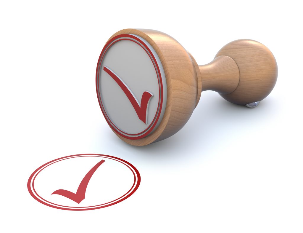 Wooden stamp with red checkmark symbol