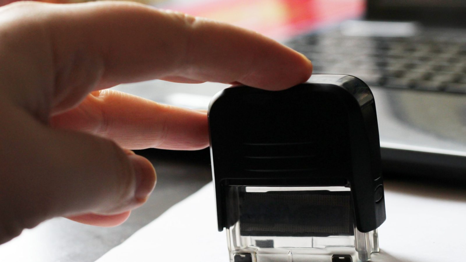 Hand using a rubber stamp on paper